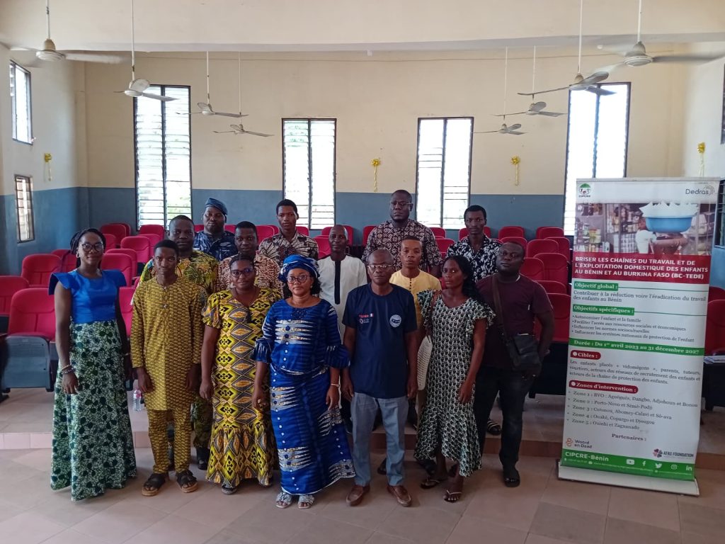 Photo de groupe hommes et femmes adultes débout à côté d'un kakémono à l'occasion d'une session annuelle du Comité Communal de Protection de l’Enfant à Sèmè-Podji dans la Vallée de l'Ouémé au Bénin.