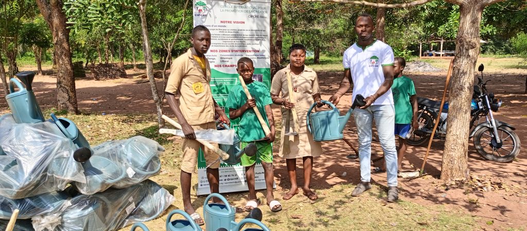 Un adulte distribue des matériels d'entretien de l'environnement à des élèves adolescents.